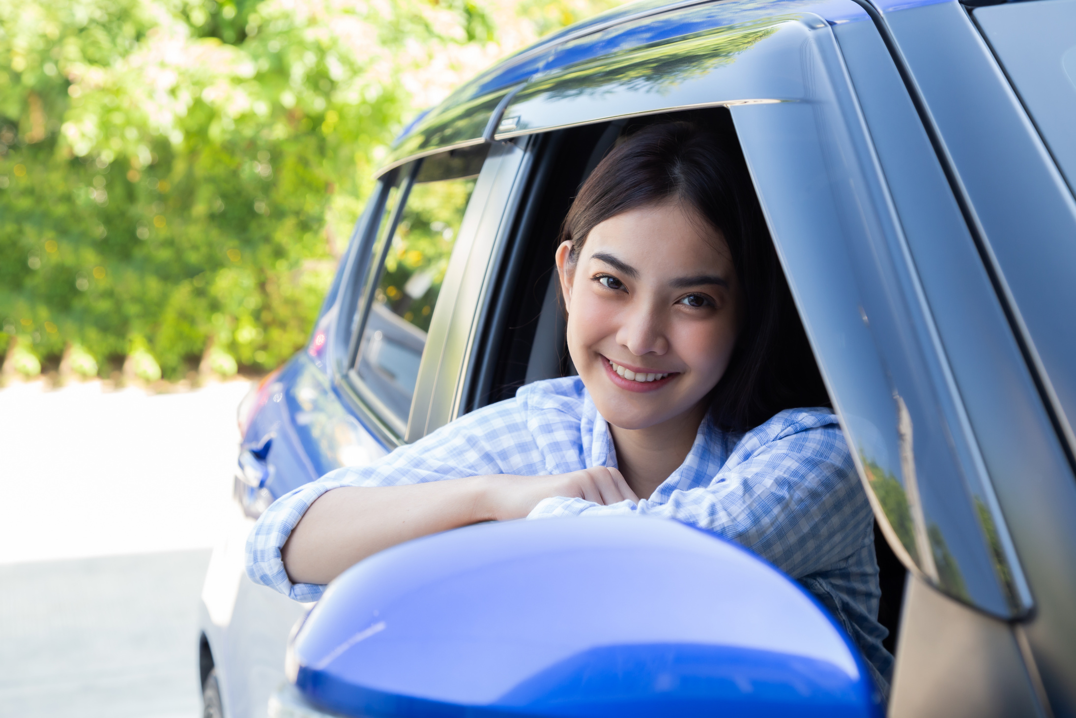 Asian women driving a car and smile happily with glad positive expression during the drive to travel journey, People enjoy laughing transport and drive thru concept
